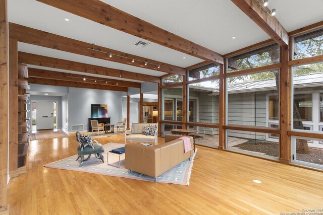 living room with visible vents, beamed ceiling, and wood finished floors