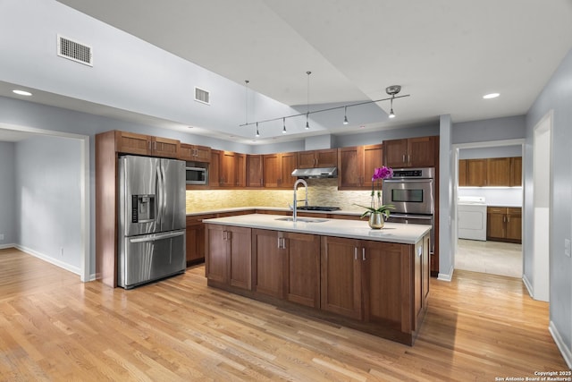 kitchen with stainless steel appliances, light countertops, visible vents, and under cabinet range hood