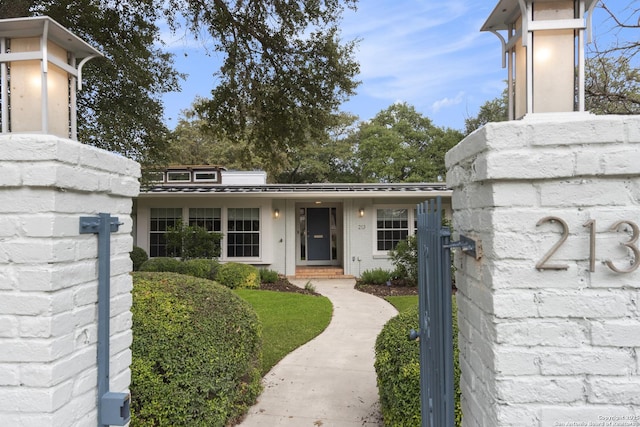 view of front of house with metal roof, brick siding, and a standing seam roof