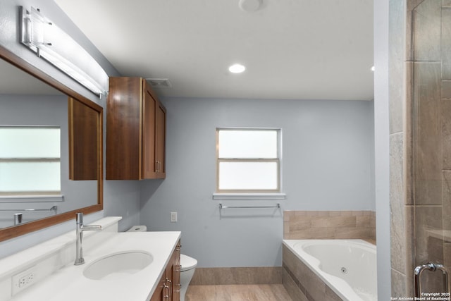 bathroom with visible vents, toilet, a shower with door, a tub with jets, and vanity