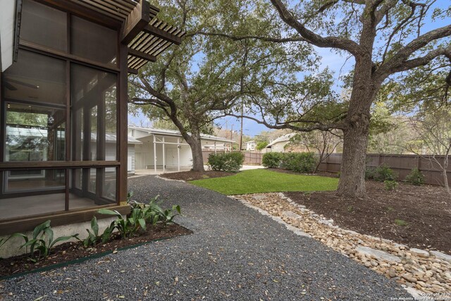 view of yard featuring a sunroom and a fenced backyard
