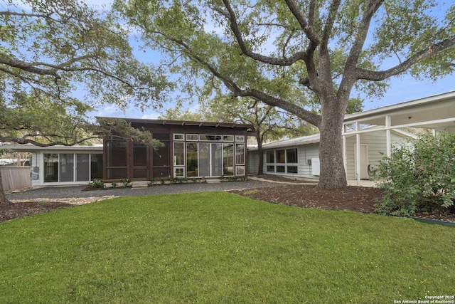 back of house featuring a sunroom and a yard
