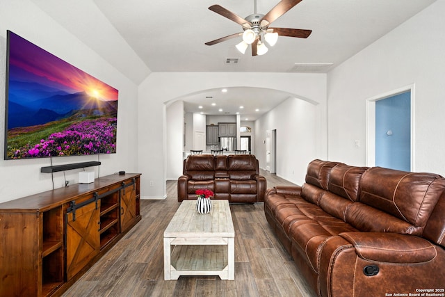 living area with a ceiling fan, arched walkways, dark wood-style flooring, and visible vents