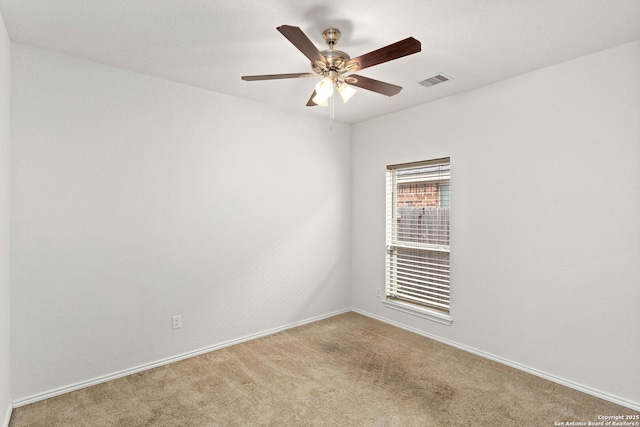 spare room featuring carpet, visible vents, ceiling fan, and baseboards