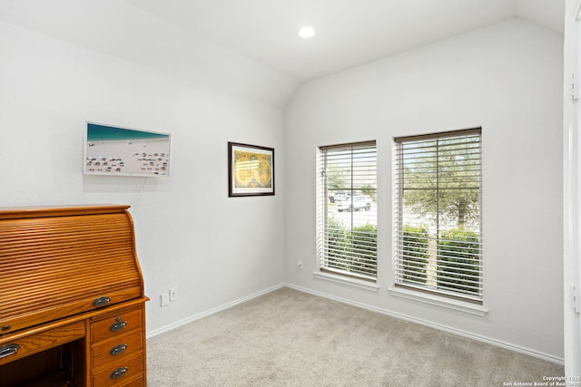 interior space featuring carpet flooring, vaulted ceiling, and baseboards