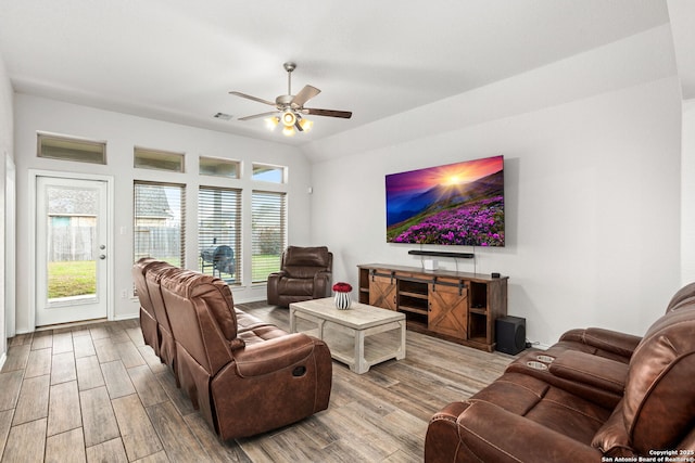 living room featuring ceiling fan, vaulted ceiling, wood finished floors, and visible vents