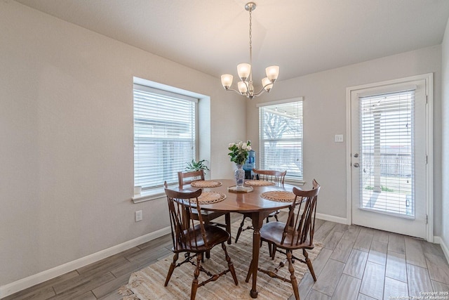 dining room with an inviting chandelier, baseboards, and wood finish floors