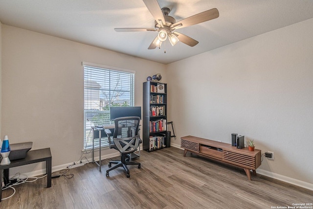 office area with a ceiling fan, baseboards, and wood finished floors