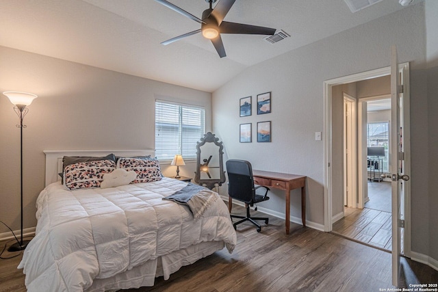 bedroom with lofted ceiling, wood finished floors, visible vents, baseboards, and a ceiling fan