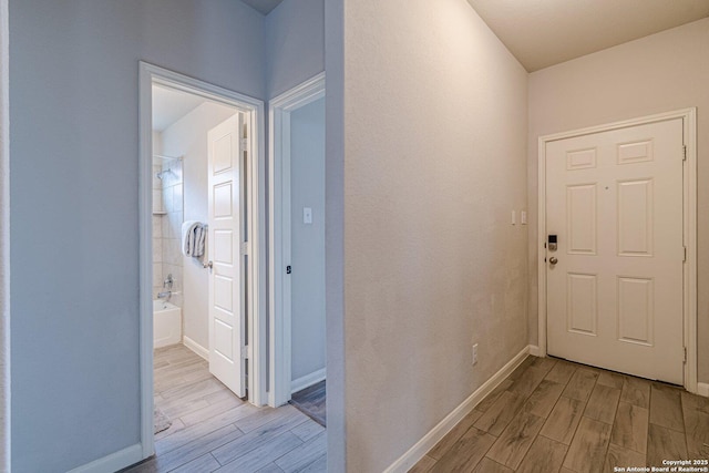 hallway featuring wood tiled floor and baseboards