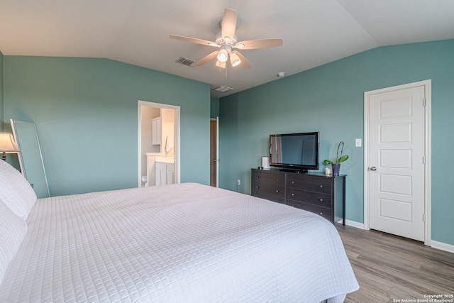 bedroom with lofted ceiling, baseboards, visible vents, and wood finished floors