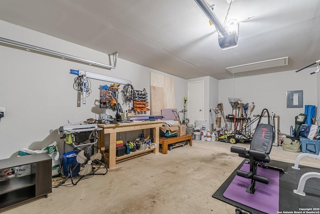 garage with a garage door opener, electric panel, and a workshop area