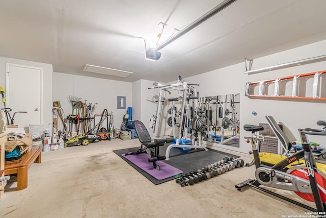 exercise area with a garage, attic access, and electric panel