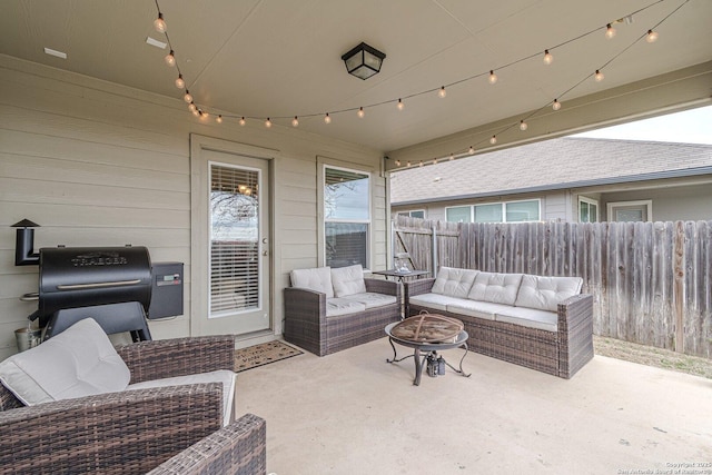 view of patio / terrace featuring fence and an outdoor living space with a fire pit