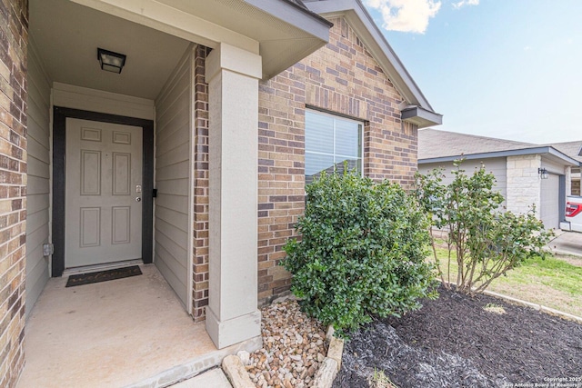 view of exterior entry with brick siding