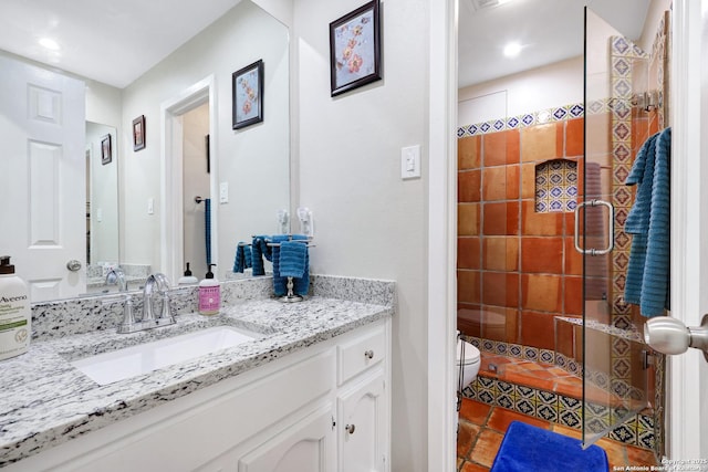 bathroom featuring toilet, a shower stall, vanity, and tile patterned floors