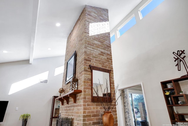 living area with a towering ceiling, visible vents, beam ceiling, and recessed lighting