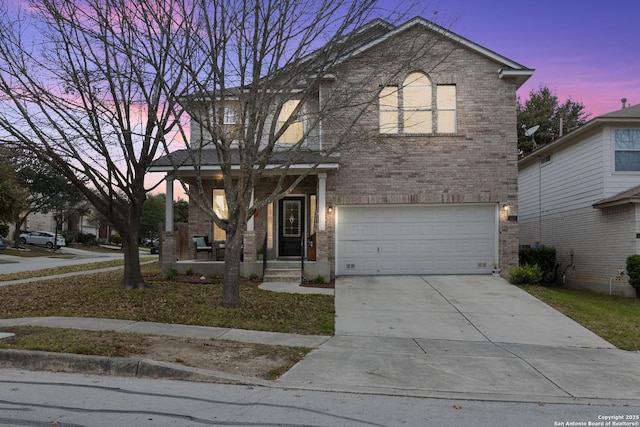 traditional-style home featuring driveway, a garage, and brick siding