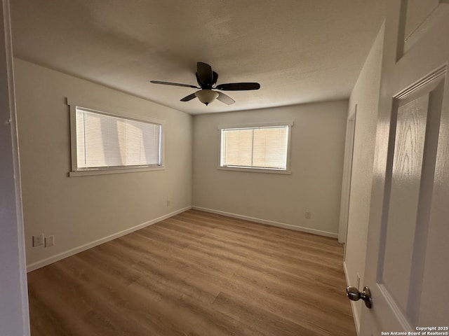 unfurnished bedroom with a ceiling fan, baseboards, and wood finished floors