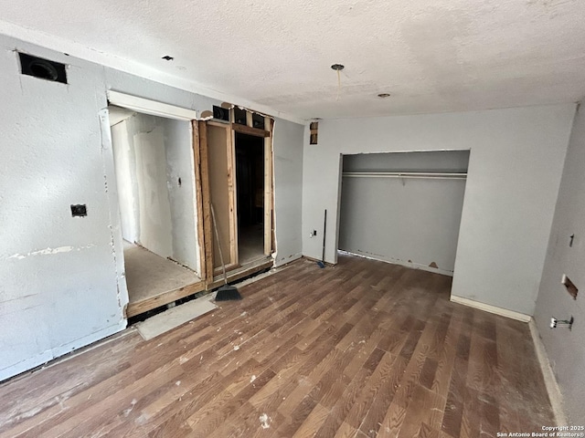 unfurnished bedroom featuring a closet, a textured ceiling, and wood finished floors