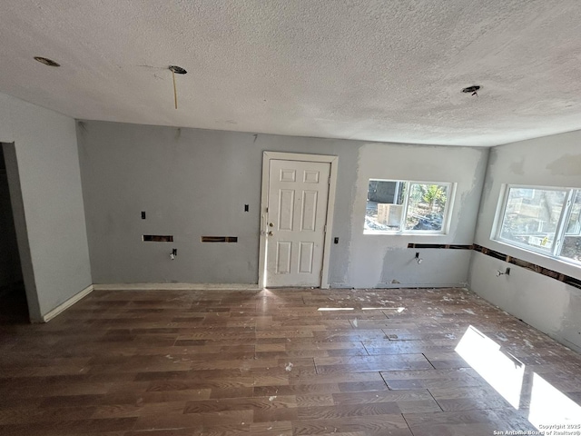 spare room featuring a textured ceiling and wood finished floors