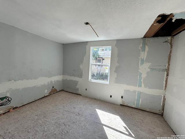 unfurnished room with a textured ceiling