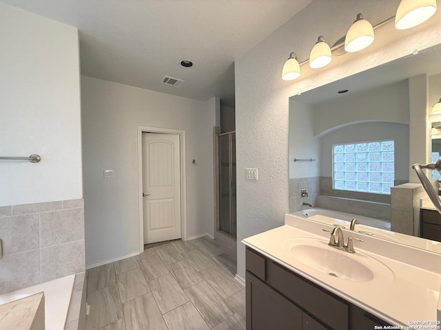 full bath featuring a garden tub, a sink, visible vents, and a shower stall