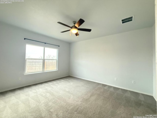 spare room featuring carpet, visible vents, ceiling fan, and baseboards