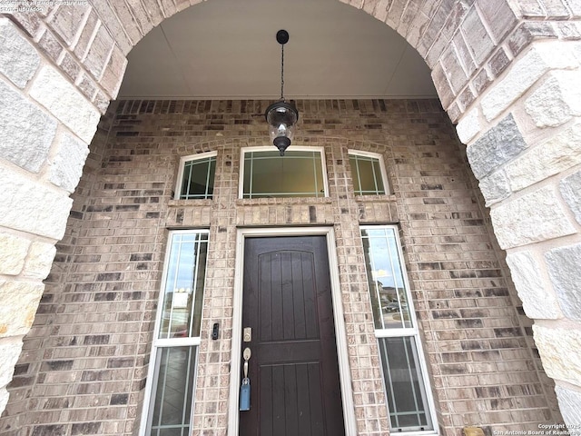 view of exterior entry with brick siding