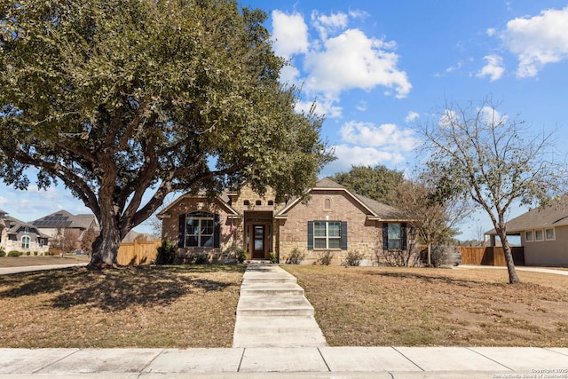 view of front of home featuring brick siding and fence