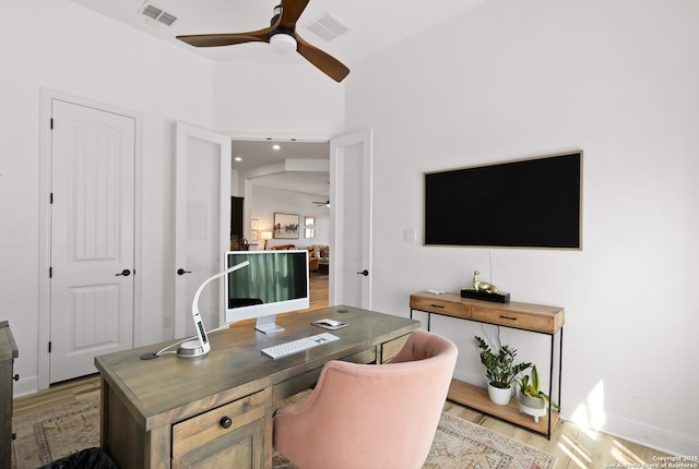 office space with a ceiling fan, baseboards, visible vents, and light wood finished floors