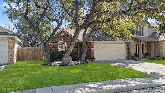 obstructed view of property featuring driveway, an attached garage, fence, a front lawn, and brick siding