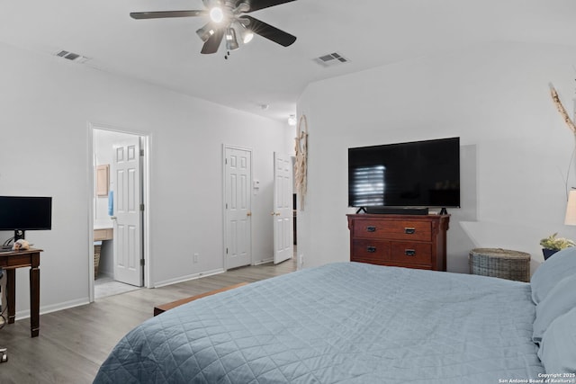 bedroom with a ceiling fan, wood finished floors, visible vents, and baseboards