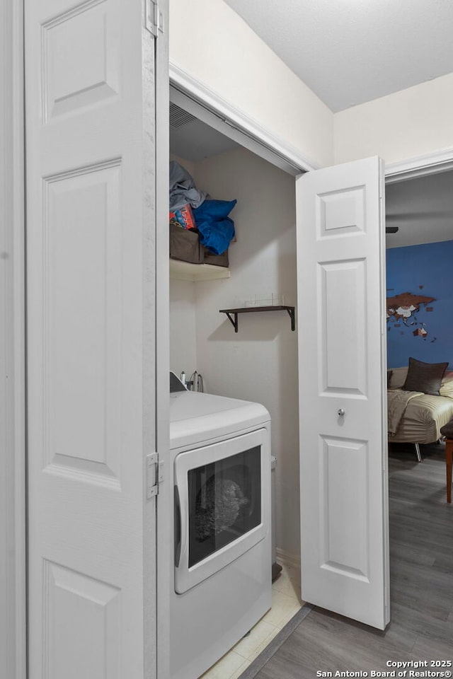 washroom with light wood-type flooring, washer / clothes dryer, and laundry area