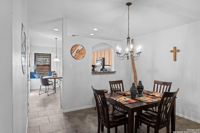 dining space featuring a chandelier, arched walkways, baseboards, and recessed lighting