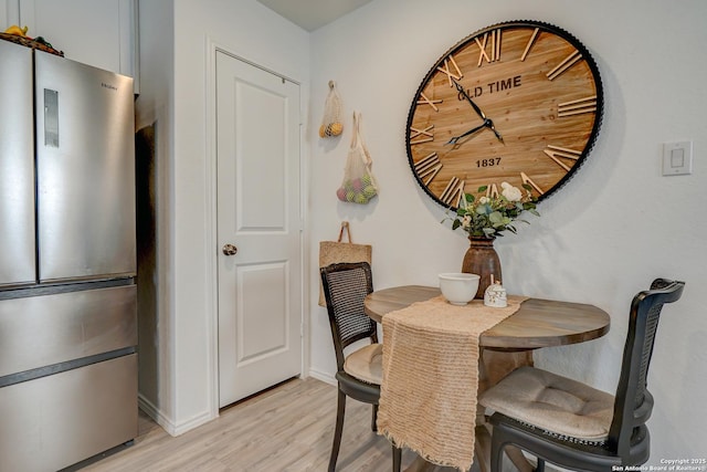 dining room with light wood-type flooring and baseboards