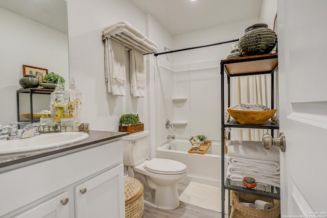 full bath featuring toilet, tub / shower combination, wood finished floors, and vanity