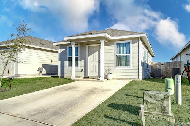 view of front of property featuring central air condition unit, fence, and a front lawn