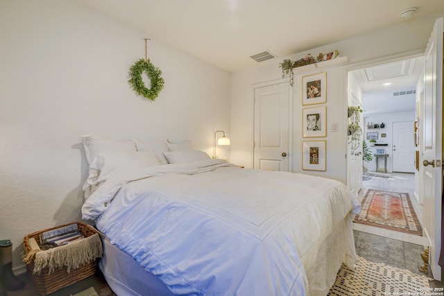 bedroom with visible vents and attic access