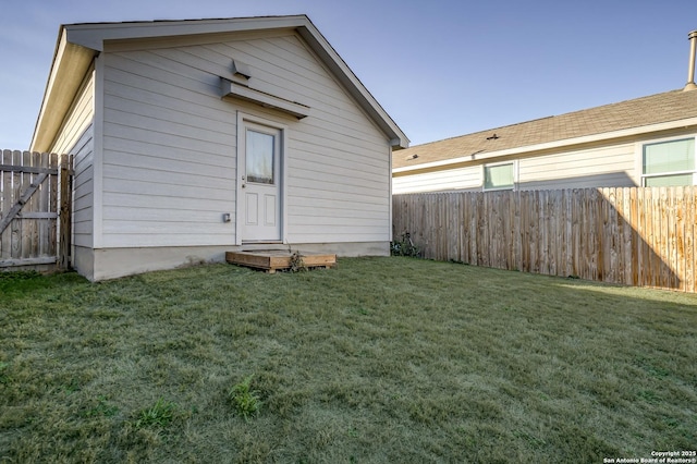 back of house featuring fence and a yard