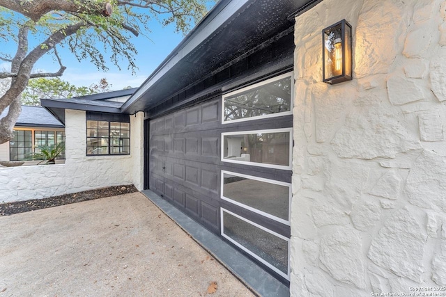 view of side of home featuring a garage and concrete driveway