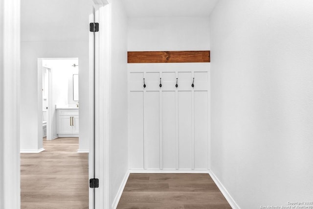 mudroom with wood finished floors and baseboards