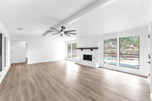 unfurnished living room featuring a fireplace, lofted ceiling with beams, light wood finished floors, and ceiling fan