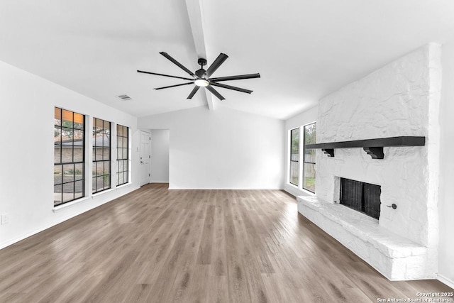 unfurnished living room with lofted ceiling, a fireplace, wood finished floors, and visible vents