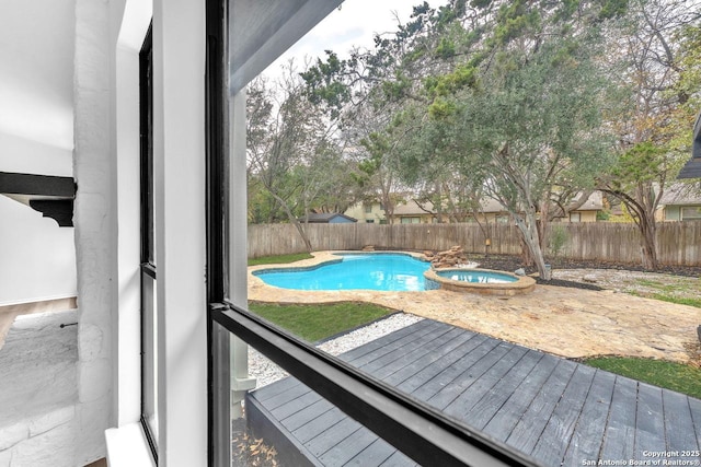 view of pool with a fenced backyard and a pool with connected hot tub