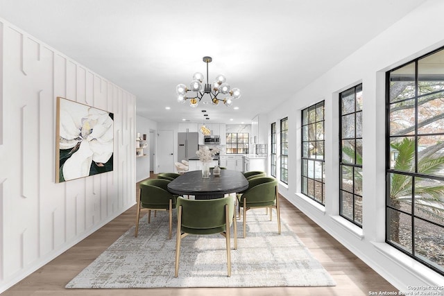 dining room with recessed lighting, wood finished floors, and an inviting chandelier