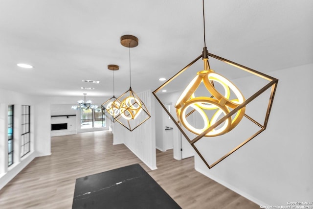 interior space with a chandelier, recessed lighting, visible vents, and wood finished floors