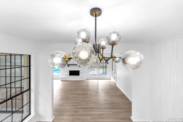 unfurnished dining area featuring a chandelier and wood finished floors