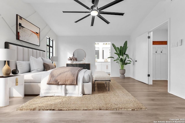 bedroom featuring lofted ceiling, ceiling fan, wood finished floors, and ensuite bathroom