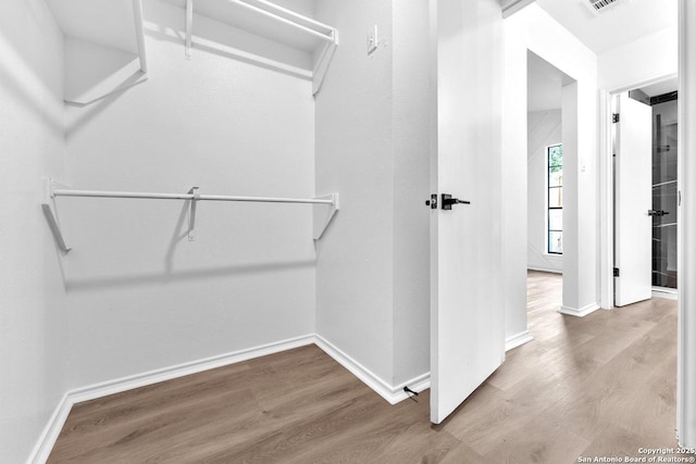 walk in closet featuring visible vents and wood finished floors